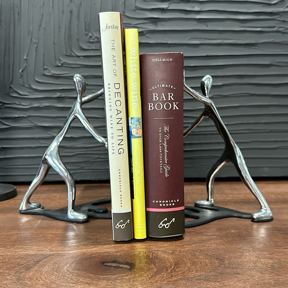 Silver and black metal people bookends
